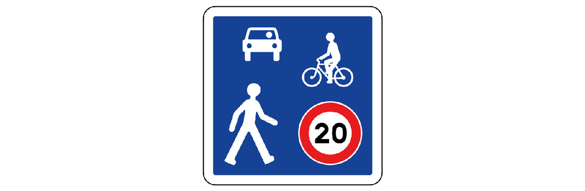 Entrée de zone de rencontre. Dans cette zone limitée à 20 km/h, le cycliste est prioritaire sur les voitures, mais il doit laisser la priorité aux piétons.