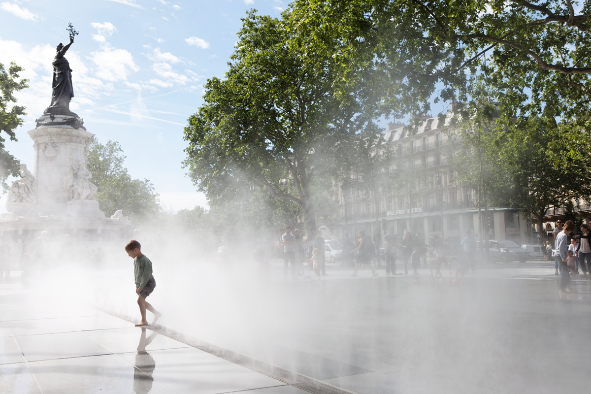 Un enfant joue dans les jets d'eau