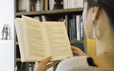 Une Parisienne lit un livre chez elle.