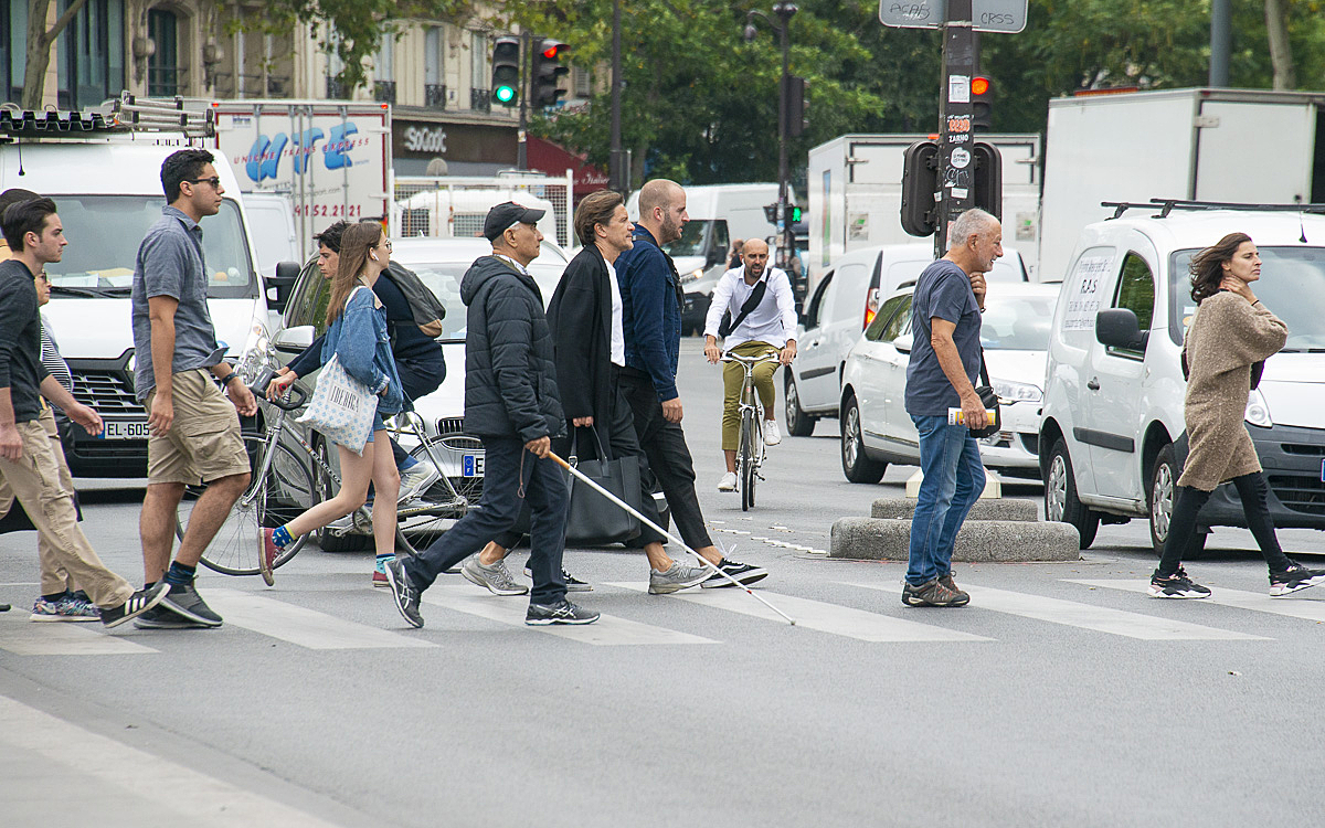 Piétons et personne malvoyante traversant sur un passage piéton