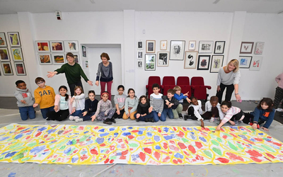 Enfants devant une fresque au sol réalisée dans le cadre de la Journée des arts plastiques
