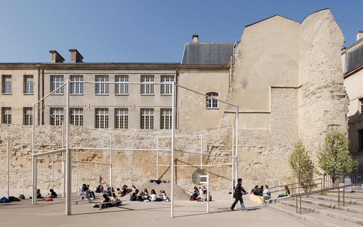 Lycéens et terrain de sport au pied du plus large tronçon du mur