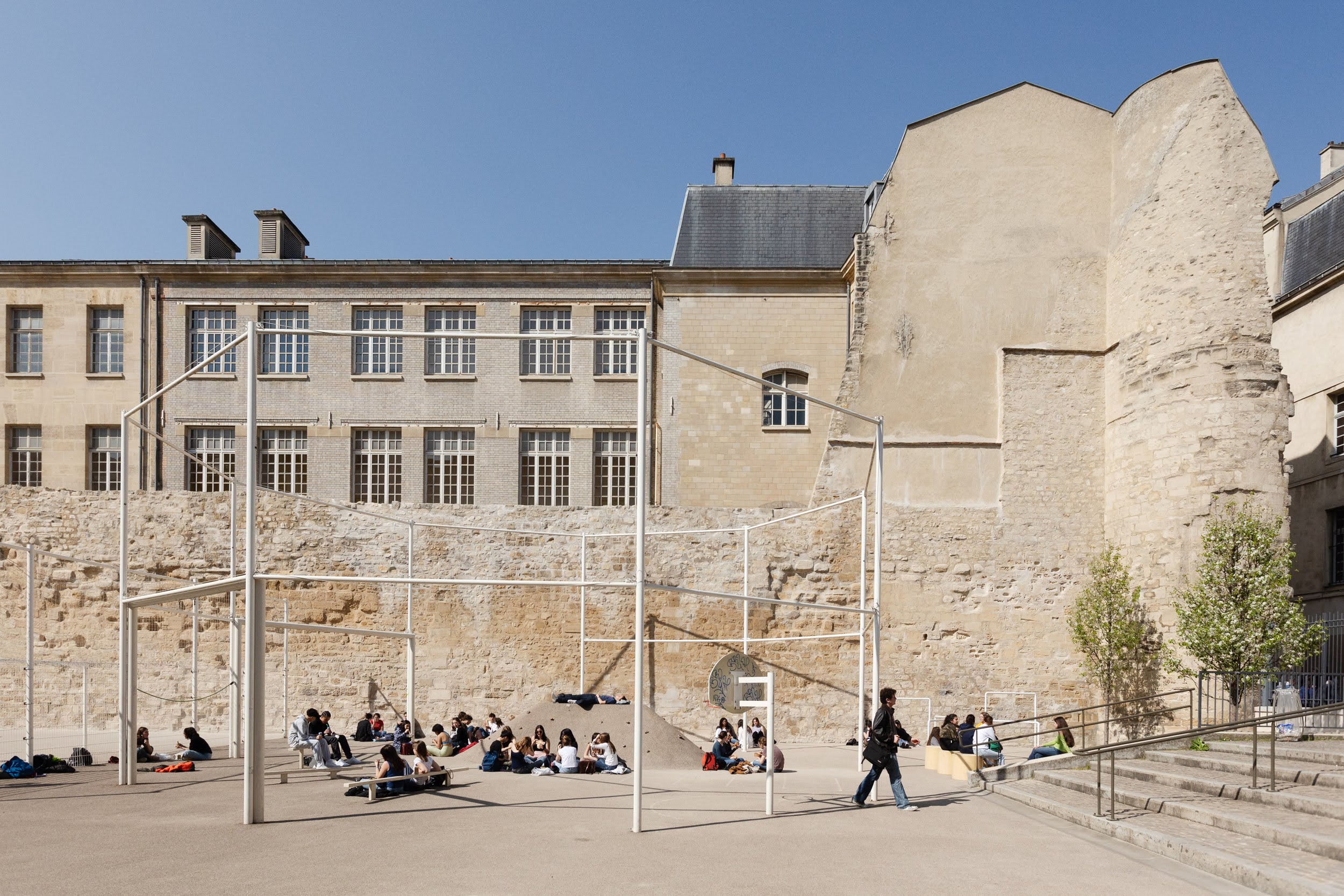 Lycéens et terrain de sport au pied du plus large tronçon du mur