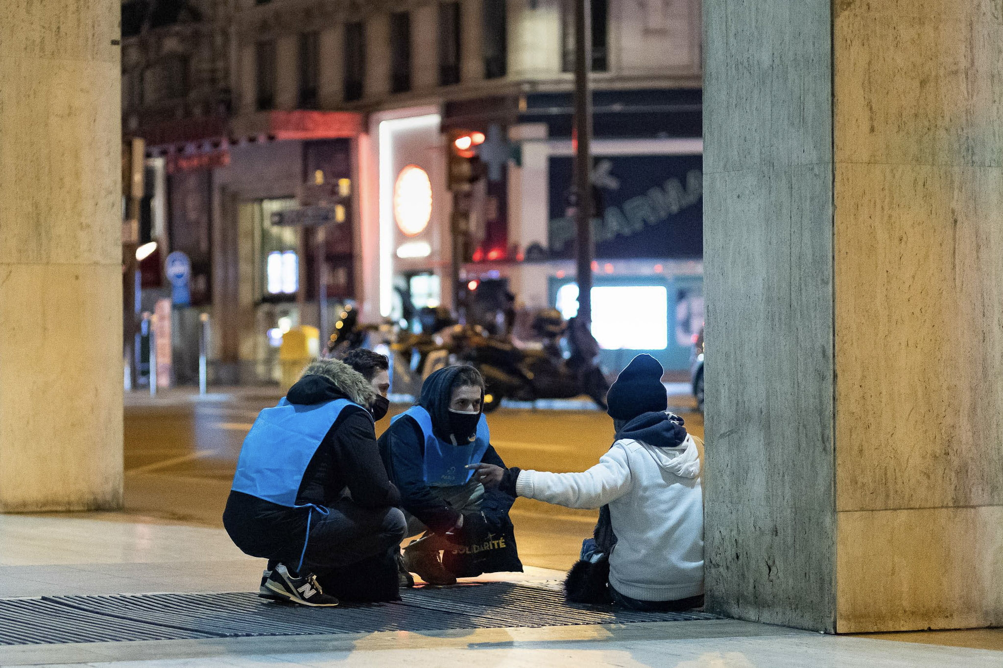 2 personnes échangent avec une personne sans abri lors de la 5e Nuit de la Solidarité à Paris.