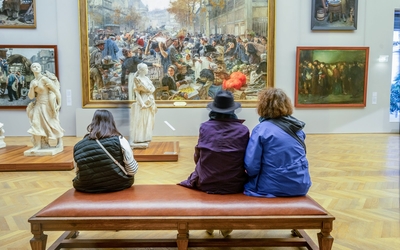 Trois personnes assises sur un banc au Petit Palais regardent une peinture de la collection permanente.