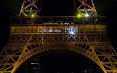 La tour Eiffel illuminée de l'inscription « La mode aime Paris » lors de la Paris Fashion Week de 2015.